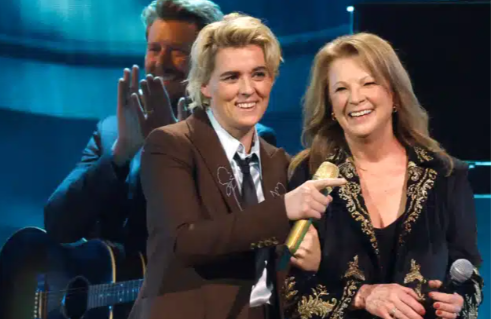 “THE WHOLE ARENA FROZE — ‘I can’t take this… it’s too emotional…’” Vince Gill fought back sobs as Patty Loveless stepped into a gentle blue spotlight with Brandi Carlile at the 2025 CMA Awards, turning what was meant to be a respectful tribute for his Willie Nelson Lifetime Achievement Award into one of the most breathtaking, tear-filled moments the ceremony has ever seen. Patty’s voice quivered with truth and pain as she delivered “When I Call Your Name,” each lyric cutting straight through Vince’s heart, while Brandi’s fragile harmonies wrapped around the song like glass. Vince covered his face, shaking, whispering, “This is… overwhelming. Thank you… thank you both…” as cameras captured trembling lips, wet cheeks, and stunned silence across the arena. When the final note faded, no one clapped. The room held a single, heavy breath — acknowledging a moment that felt almost holy.